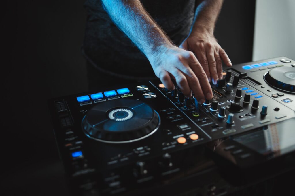 Closeup of a DJ working under the lights against a dark background in a studio